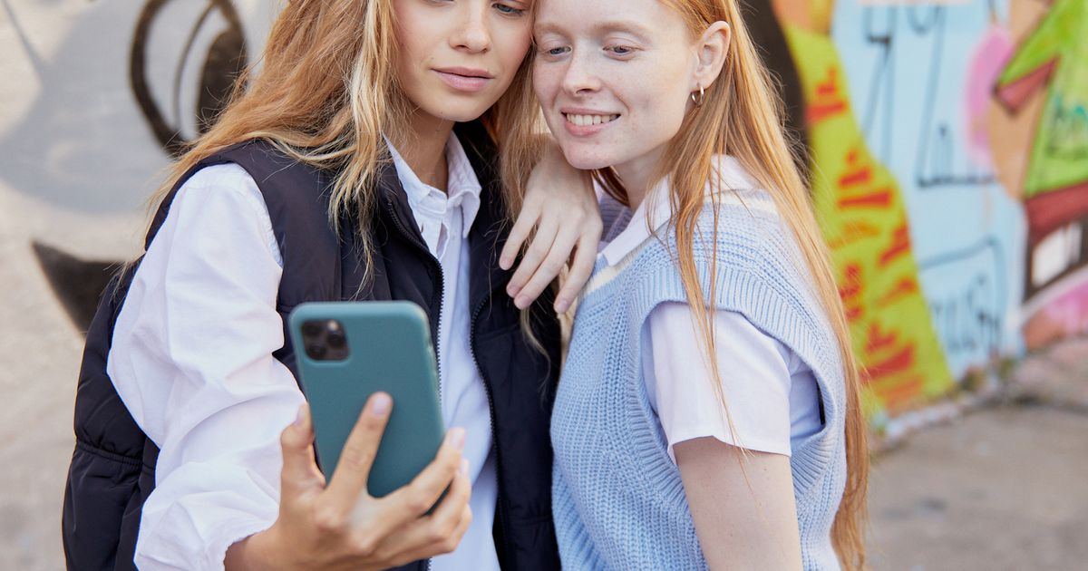 Duas amigas gravando selfie casual com smartphone